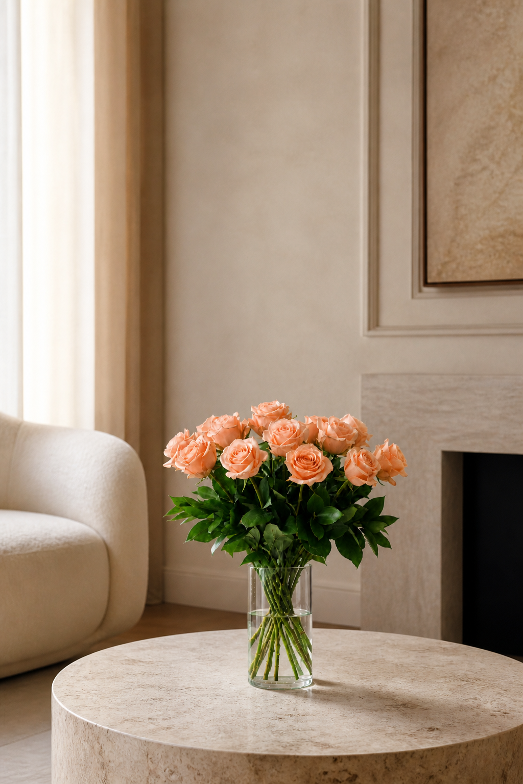 Peach rose arrangement in a clear vase styled in a warm contemporary interior with soft natural light and minimal decor.