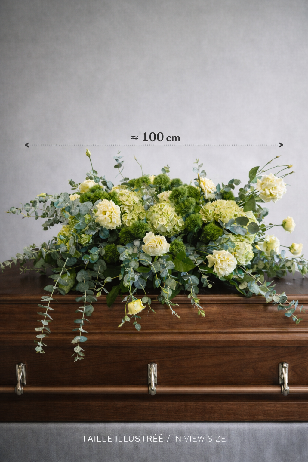 Large sympathy casket spray approximately 100 cm wide with pale yellow lisianthus, green hydrangeas, textured green dianthus and eucalyptus on a walnut coffin with size reference text.