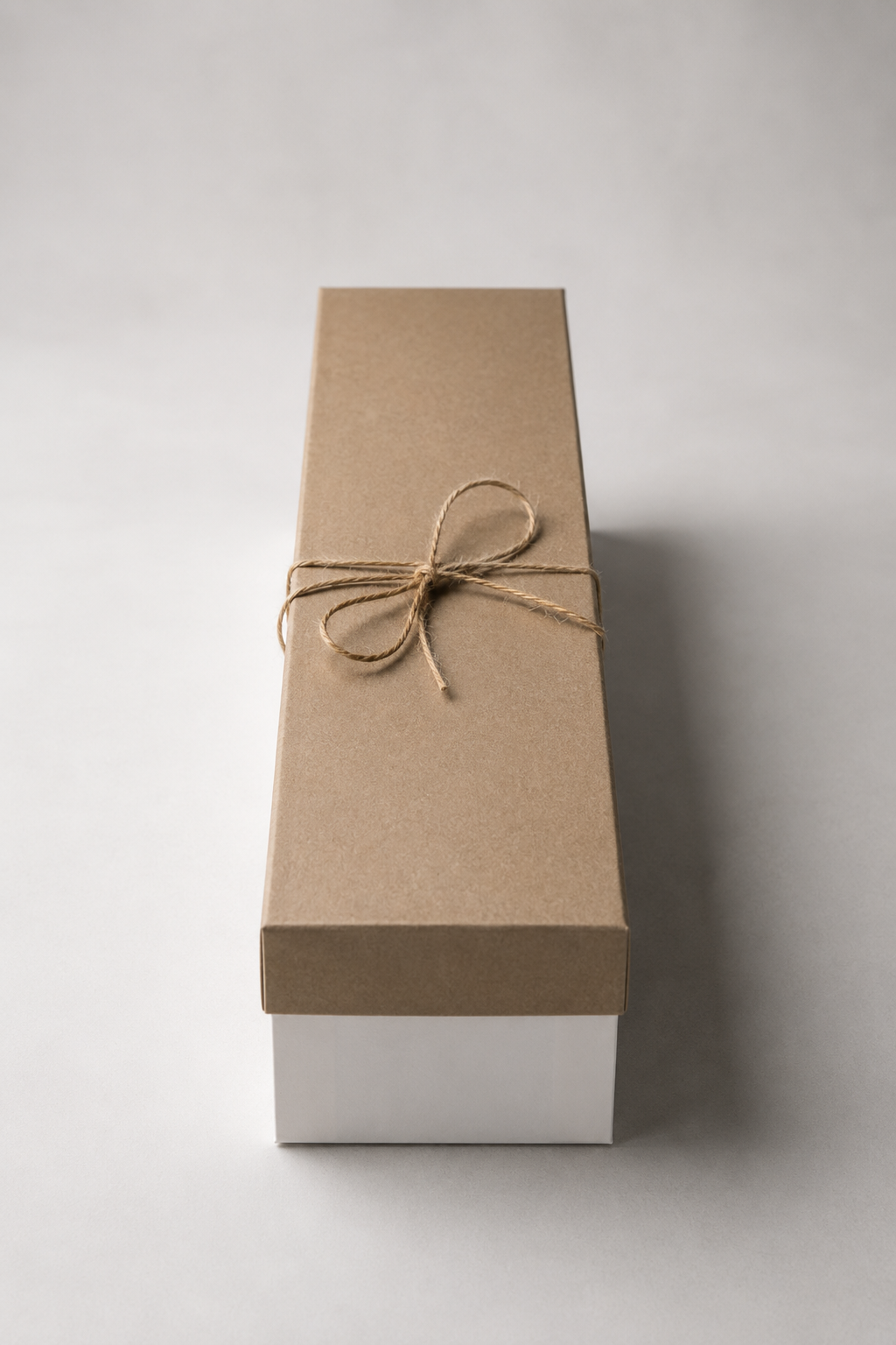 Closed long floral gift box for red roses, shown  with a white base, kraft lid, and twine bow for elegant flower delivery Montreal.