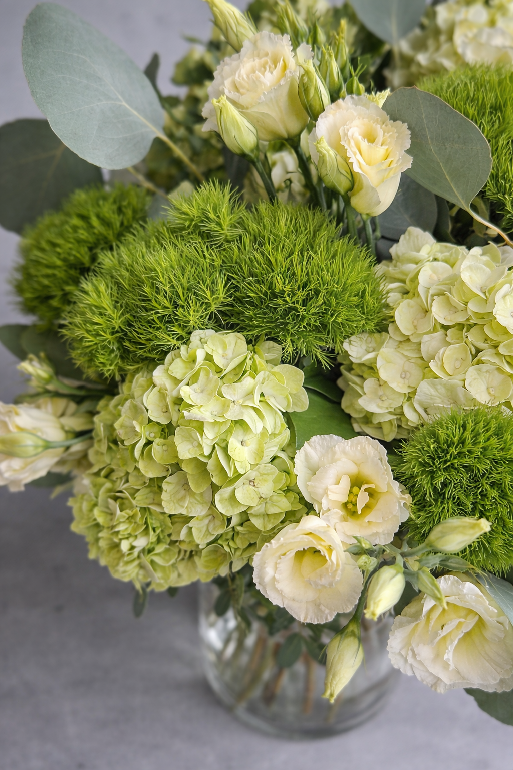 Top view of green hydrangea and lisianthus arrangement with lush foliage by a Montreal florist
