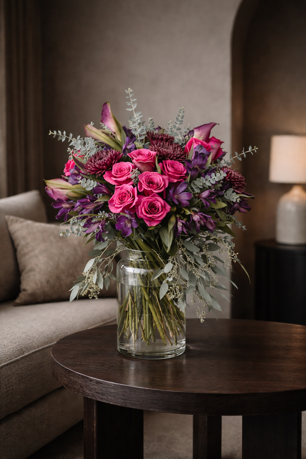 Premium pink rose and purple floral arrangement in dark contemporary interior setting