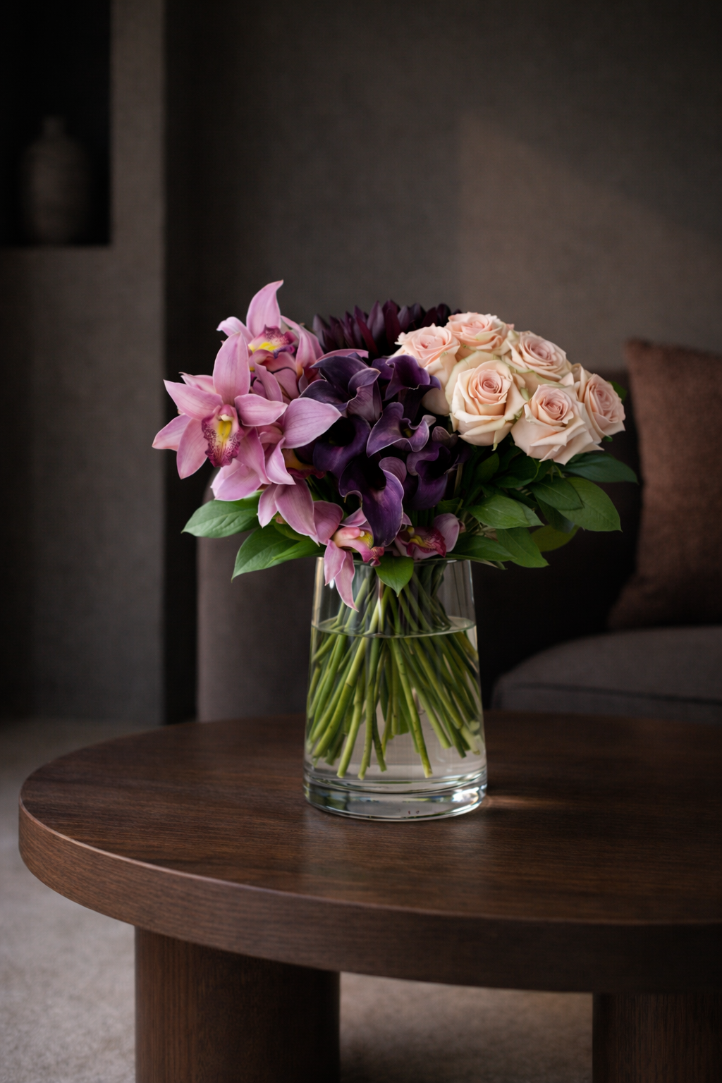 Elegant orchid, calla lily and blush rose bouquet styled in dark contemporary living room, Montreal luxury florist