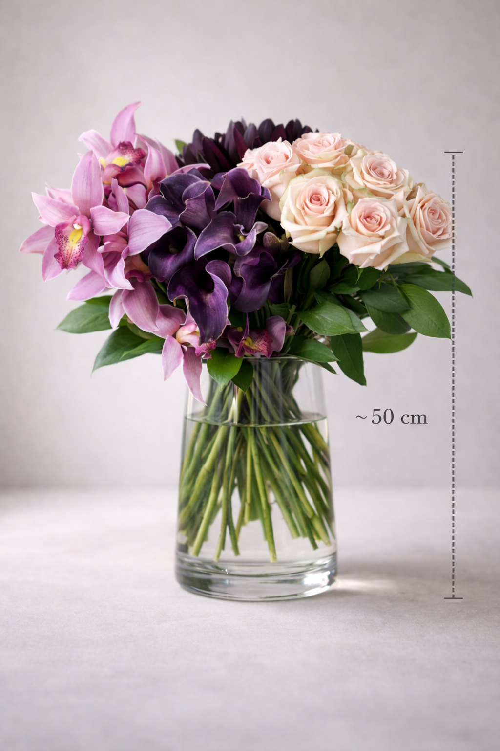 Luxury orchid, deep purple calla lily and blush rose bouquet approximately 50 cm tall in clear glass vase, Montreal luxury florist design