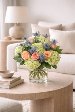 Luxury peach rose hydrangea and blue eryngium bouquet styled in modern interior Montreal flower delivery