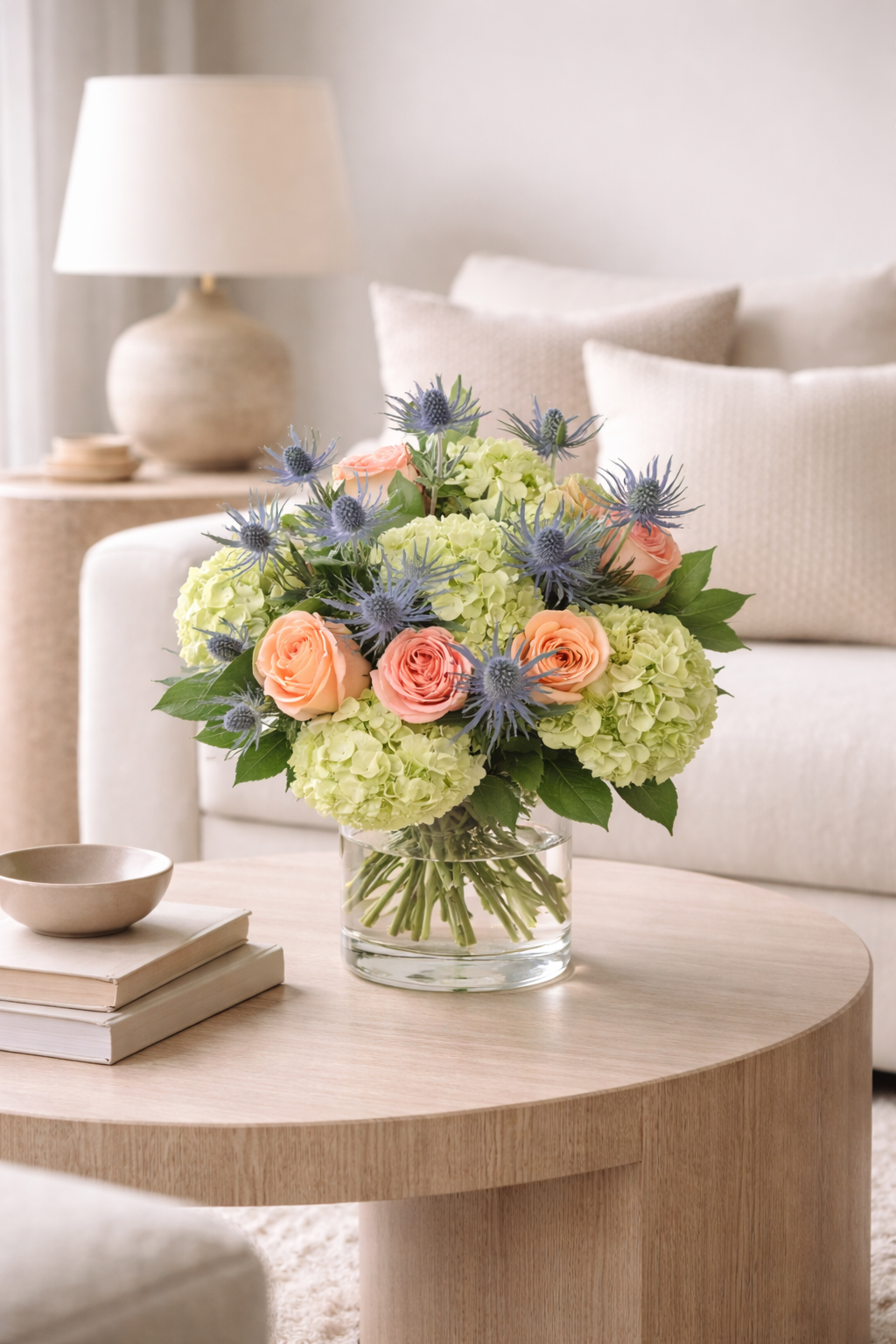 Luxury peach rose hydrangea and blue eryngium bouquet styled in modern interior Montreal flower delivery
