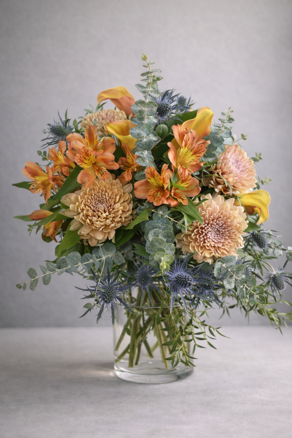 Luxury seasonal flower bouquet in a clear glass vase, photographed front-facing by a Montreal florist.