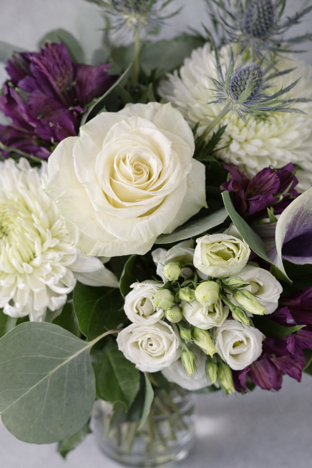 Top view of a luxury white and purple floral bouquet with rose lisianthus calla and foliage in Montreal