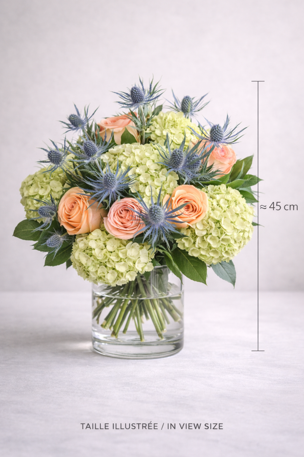Peach rose hydrangea and blue eryngium bouquet approximately 45 cm tall in glass vase Montreal florist arrangement