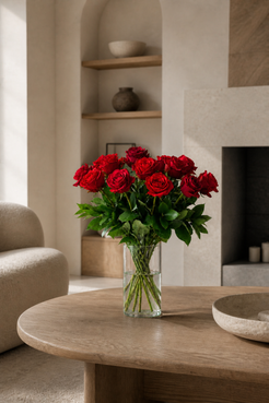 Red Freedom rose bouquet in a clear vase styled in a cosy contemporary interior with soft natural light, suited to a premium bouquet Montreal and same-day flower delivery Montreal page.