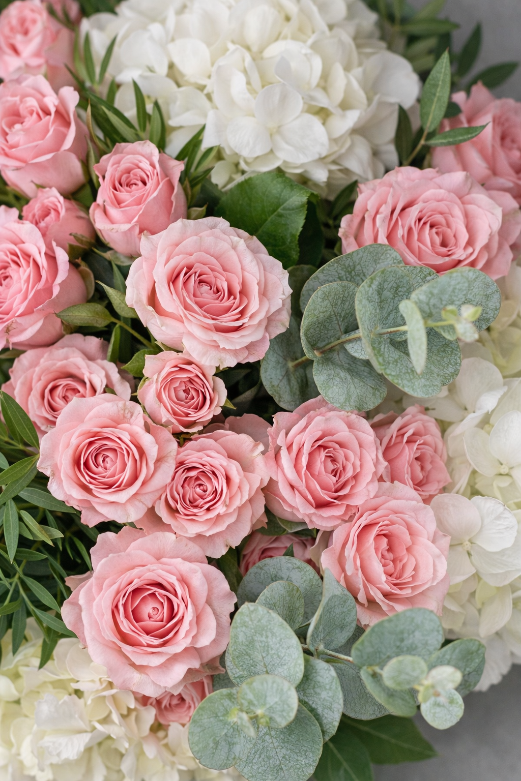 Top view of pink roses white hydrangeas and eucalyptus with visible botanical texture for Montreal flower delivery