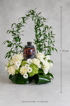White and green urn floral arrangement with roses, lisianthus and folded tropical foliage shown with a 70 cm size reference, photographed for luxury flowers Montreal.