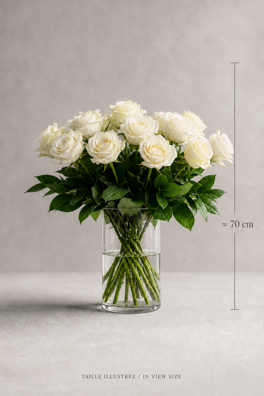 White cream Mondial rose bouquet in a clear glass vase with elegant size reference, shown as an editorial premium bouquet Montreal image with balanced front composition and fresh foliage.